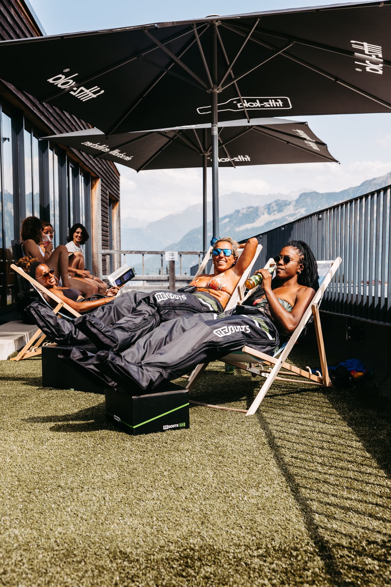 Teilnehmer entspannen nach dem Trailrunning auf der Lodge Terrasse