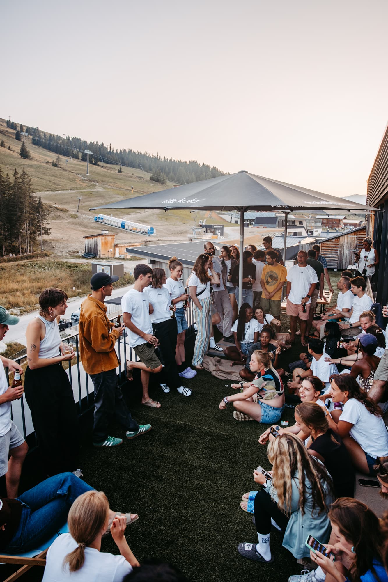 Large group gathering on lodge terrace at sunset