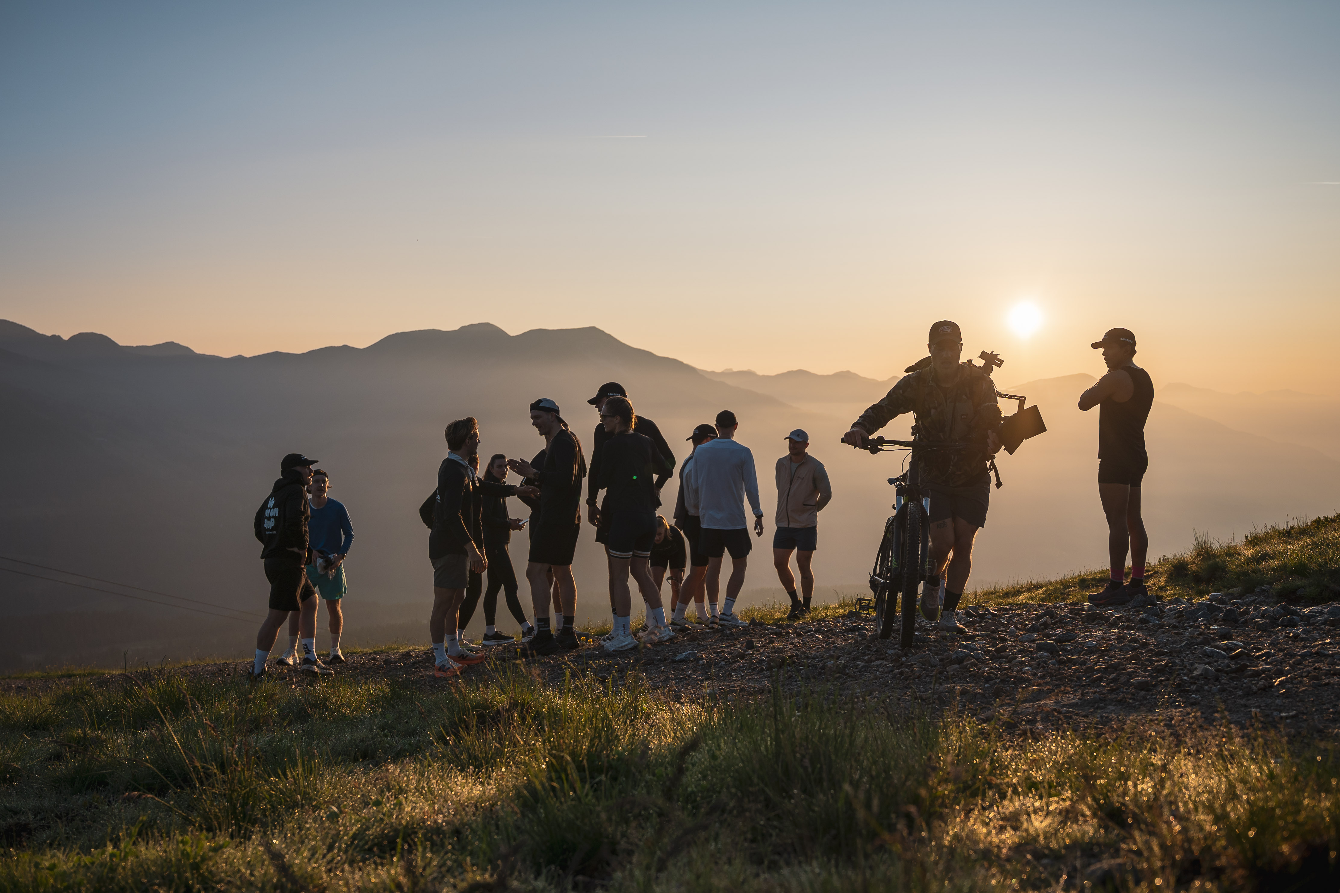 Trail running group on mountain ridge at sunrise